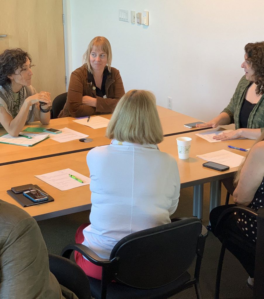 woman gathered around a table discussing project