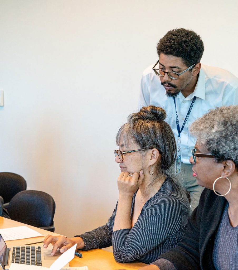 man assisting woman with her computer